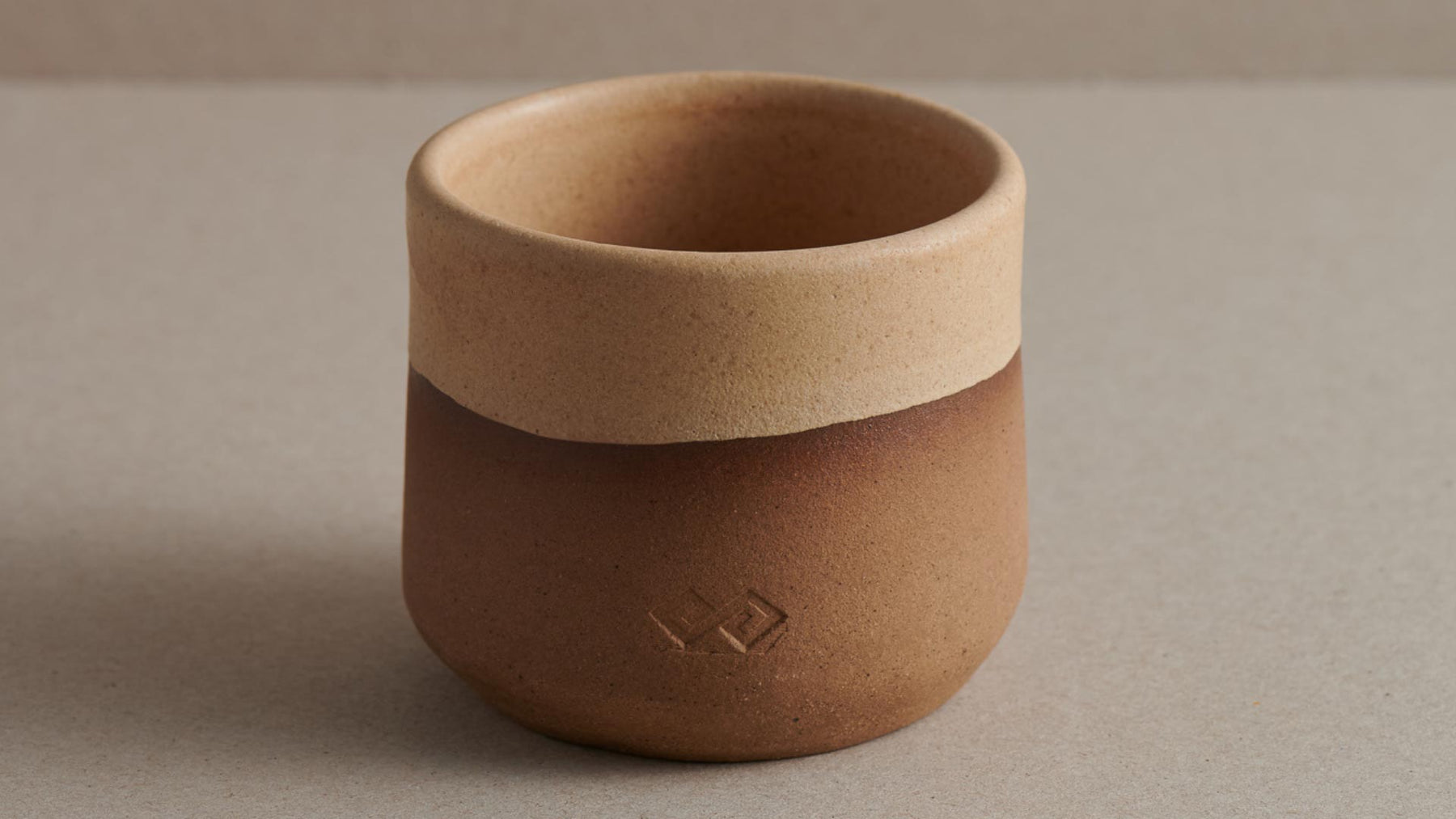 handmade ceramic cup in beige and brown colour on surface f zeen boutique